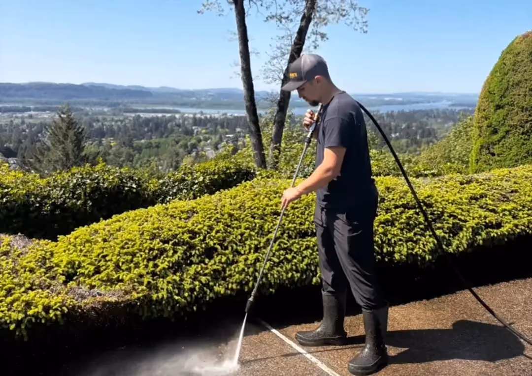Cascade Armor owner Tim pressure washing a patio overlooking the Northwest landscape